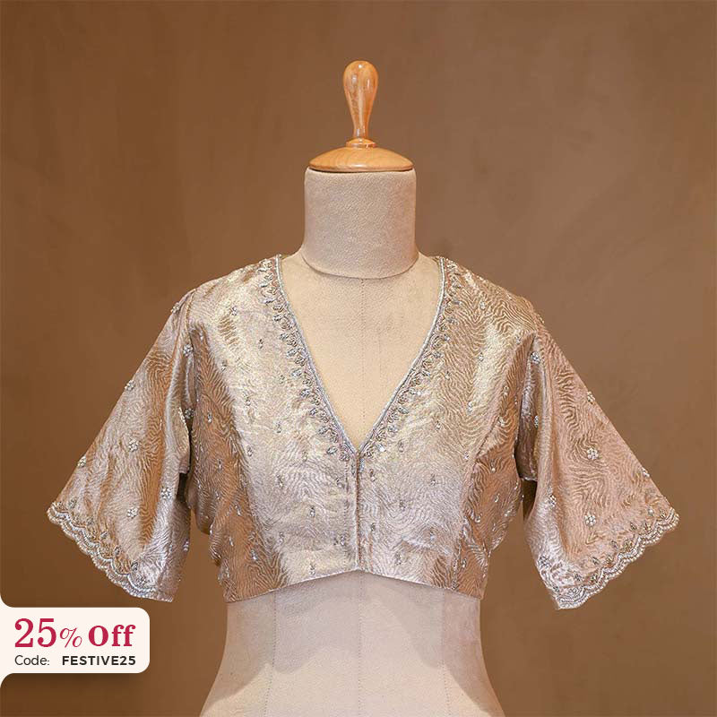 A Silver designer blouse on a mannequin with a promotional text Diwali sale offer on blouses up to 50%

