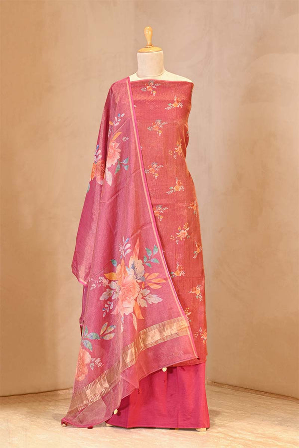Pink saree with floral patterns on a mannequin against a beige background