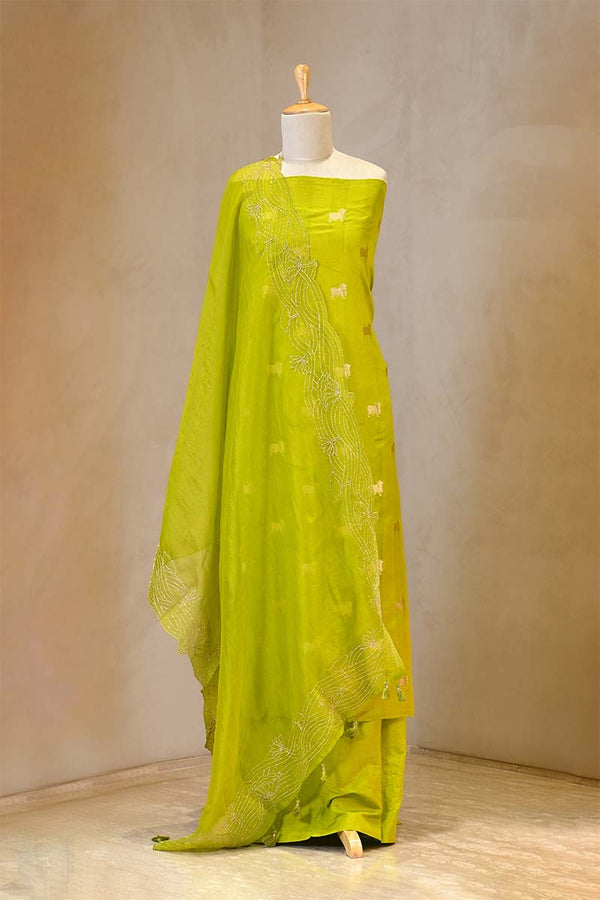 green suit set with intricate patterns on a mannequin against a plain background