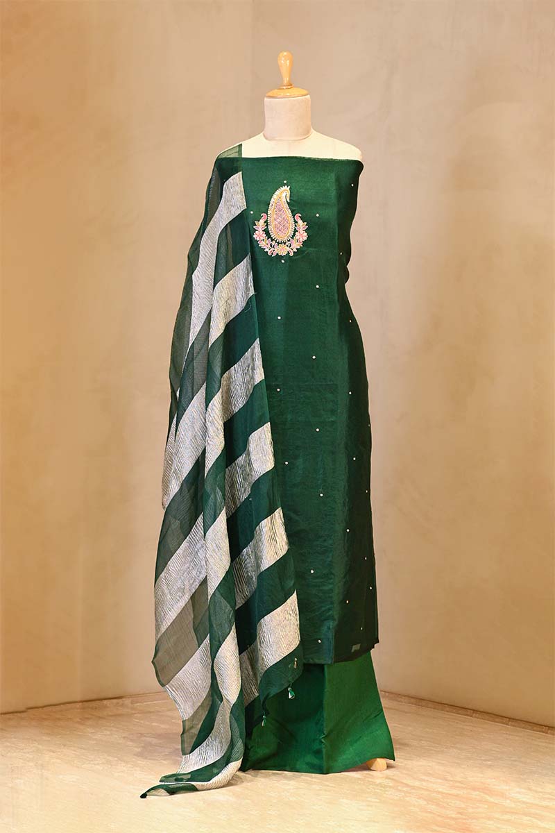 Green saree with a striped pattern on a mannequin against a beige background