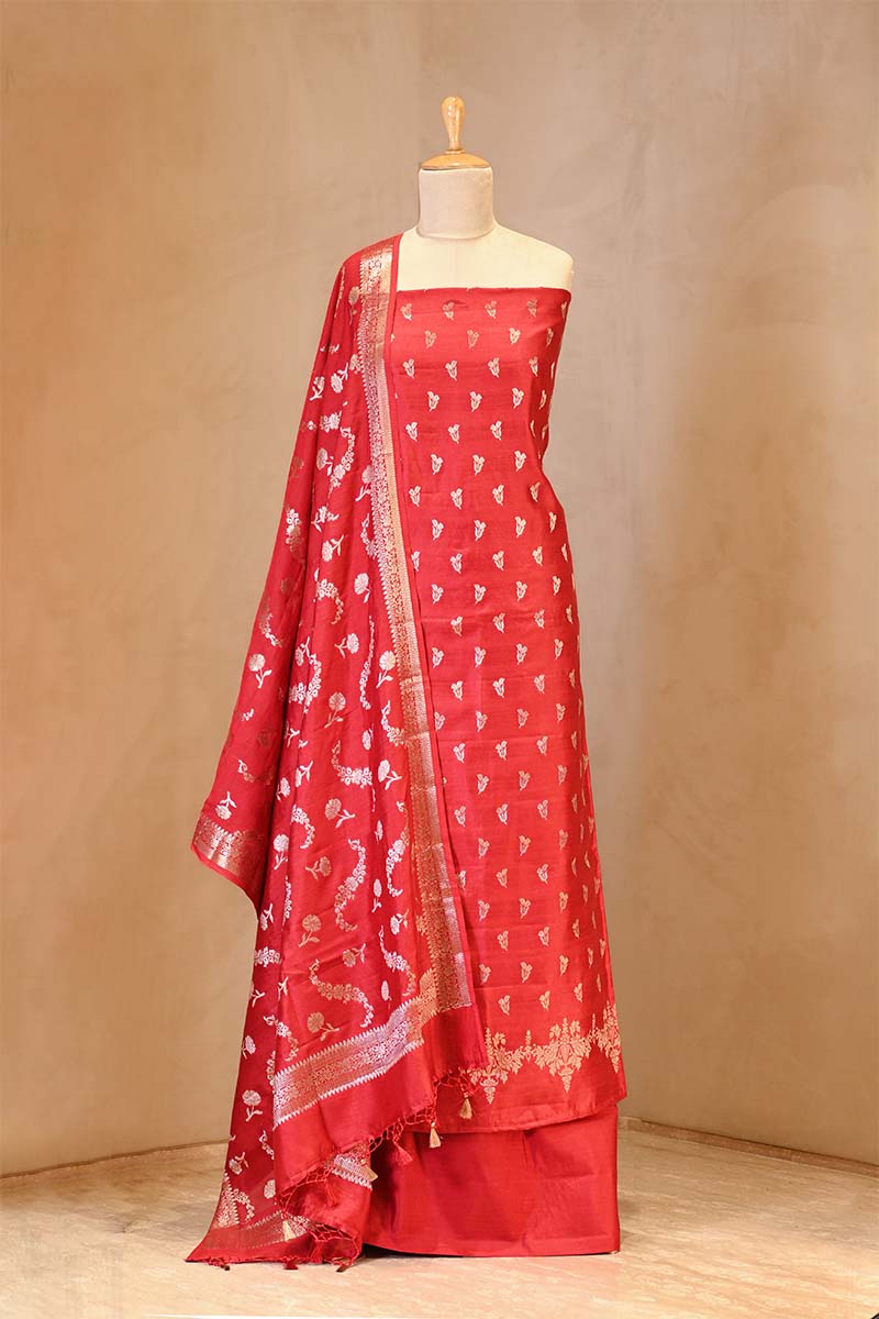 Red saree with white patterns on a mannequin against a beige background