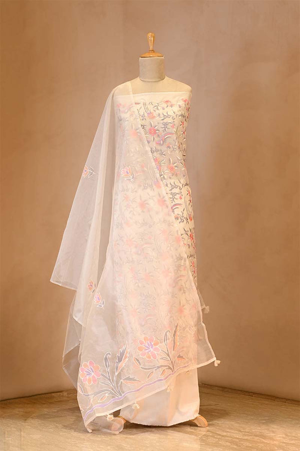 White embroidered dress on a mannequin against a beige background