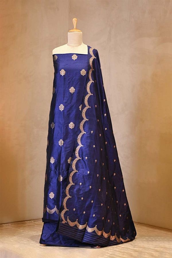 Blue saree with gold patterns on a mannequin against a neutral background