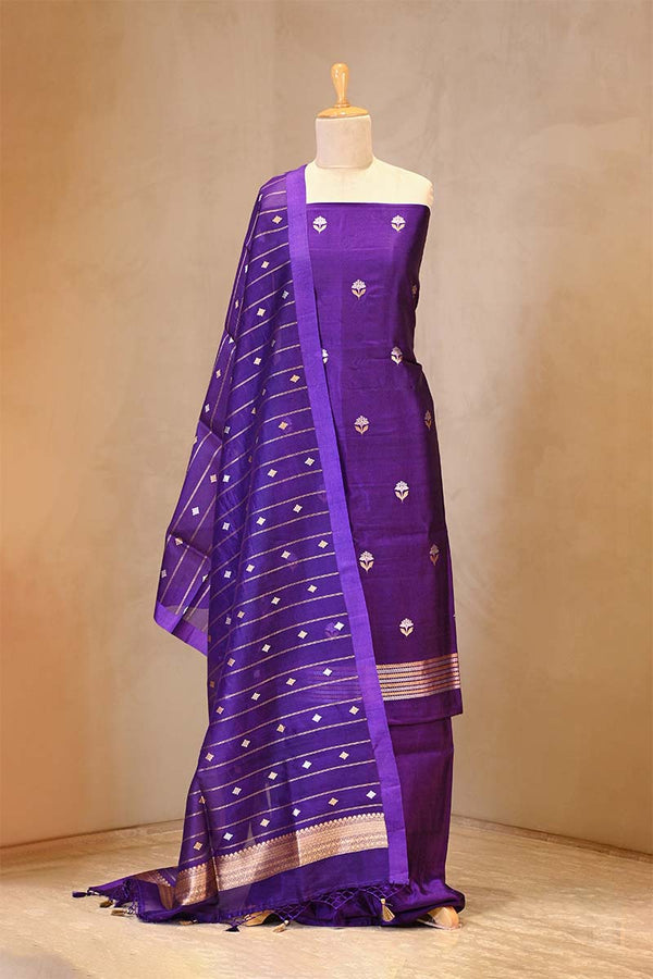 Purple saree with white patterns on a mannequin against a beige background