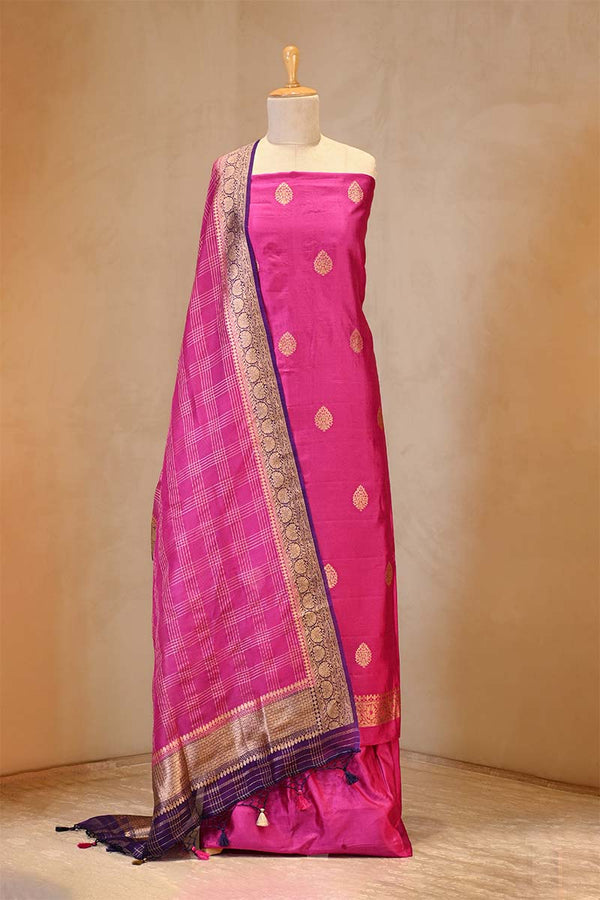 Pink saree with gold border on a mannequin against a neutral background