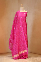 Pink saree with white patterns on a mannequin against a beige background