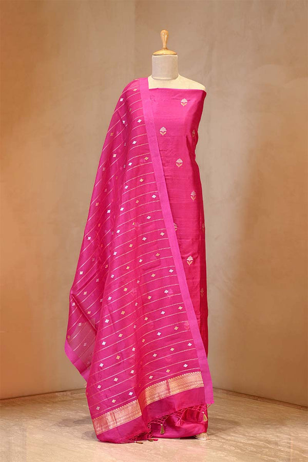 Pink saree with white patterns on a mannequin against a beige background