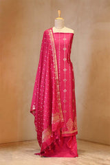 Pink traditional outfit with white patterns on a mannequin against a beige background