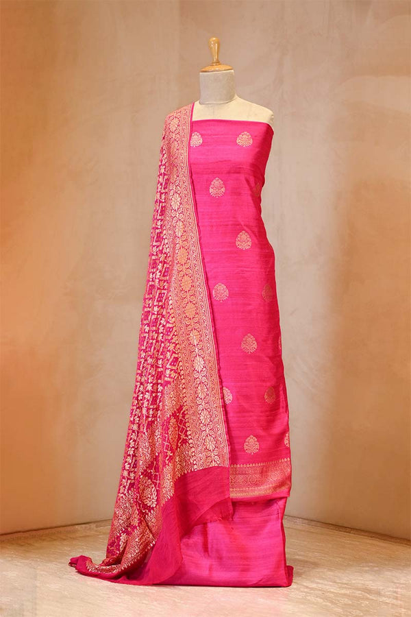 Pink saree with gold patterns on a mannequin against a beige background