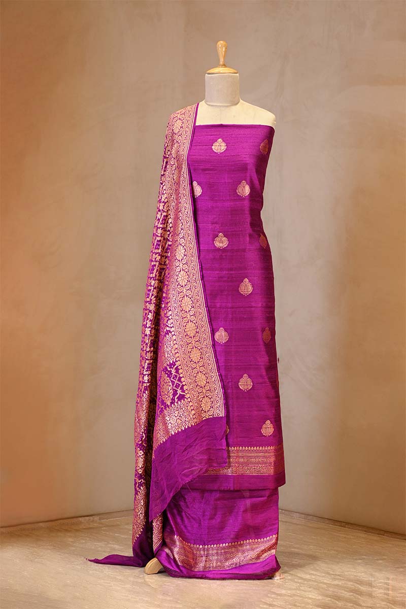 Purple saree with gold patterns on a mannequin against a beige background
