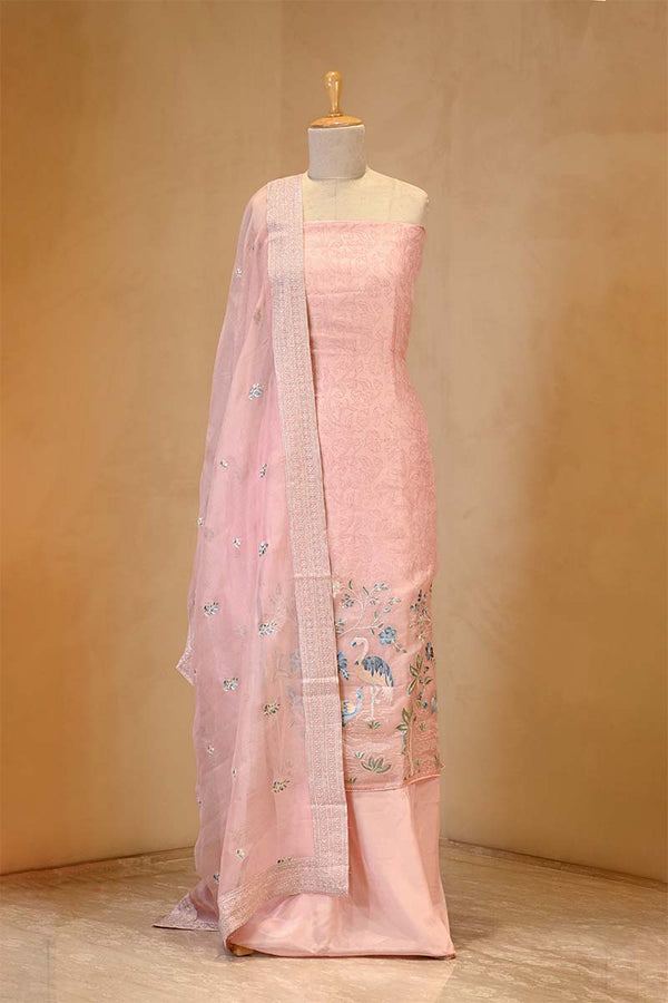 Pink saree with floral patterns on a mannequin against a beige background