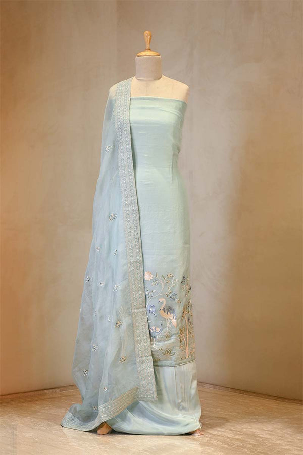 Light blue saree with intricate designs on a mannequin against a beige background