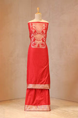 Red dress with floral patterns on a mannequin against a plain background