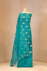 Teal suit with elephant patterns on a mannequin against a beige background