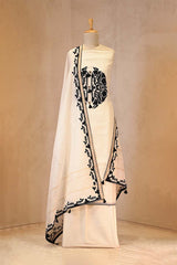 White fabric with black floral pattern draped over a mannequin against a neutral background