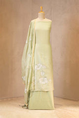 Light green traditional outfit with floral patterns on a mannequin against a beige background