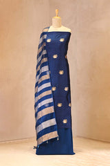 Blue suit set with gold patterns on a mannequin against a beige background