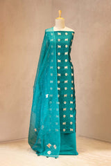 Teal blue with white patterns on a mannequin against a beige background