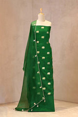 Close up of emerald green Chiniya Silk Suit Set showing the unstitched top fabric with Gaja motifs and the organza dupatta with gota patti and cutdana border.
