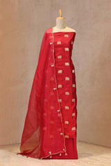 Close up of Red Chiniya Silk Suit Set showing the unstitched top fabric with Gaja motifs and the organza dupatta with gota patti and cutdana border.