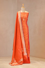 Gold zari woven vertical stripes and a Zardozi embroidered V-neckline on an orange Banarasi Katan silk unstitched suit set paired with a contrast border Konia paisley dupatta.