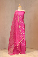 Gold zari woven ethnic buti and on Rani pink Chiniya silk unstitched suit set with an embroidered organza dupatta.
