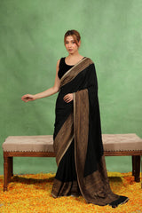 Women wearing Black Crepe Silk Reception wear Saree showing antique zari floral border and handcrafted lace detailing.