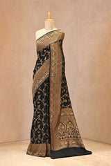 Close up of Black Crepe Banarasi Khaddi Silk Saree showing handloom woven gold zari Shikargah floral jaal on the body and borders.