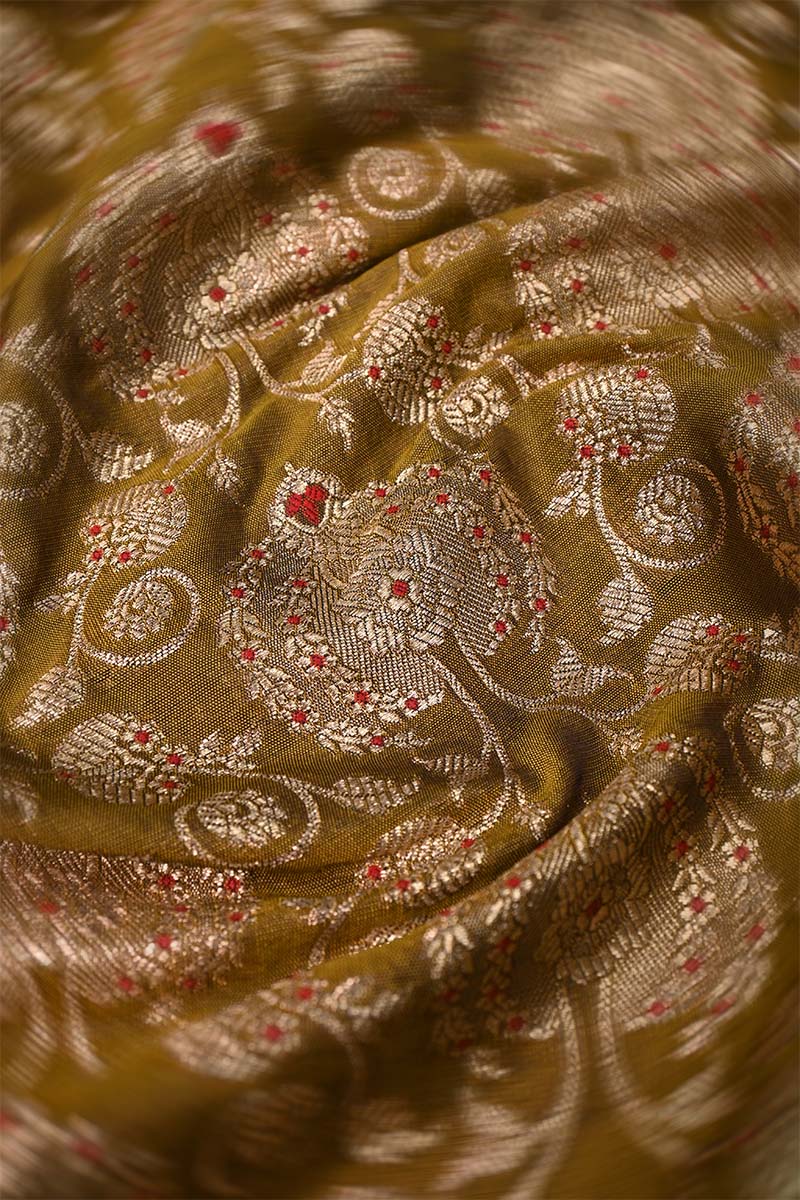 Close-up of a patterned fabric with intricate designs on a yellow background