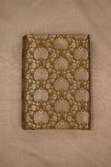 Close-up of embroidered woven Banarasi silk fabric with intricate patterns on beige background