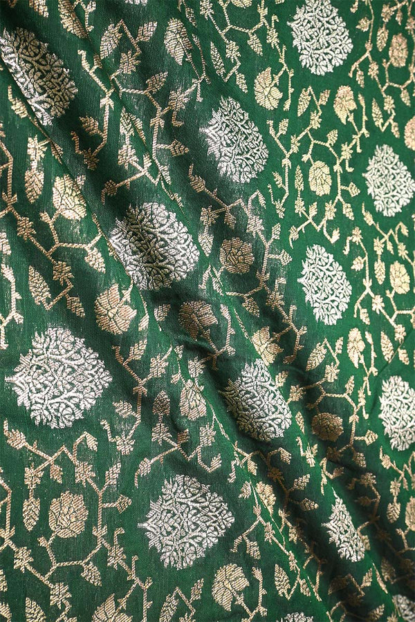 Green Banarasi silk fabric with intricate gold and silver floral pattern
