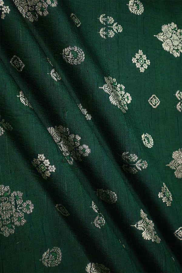 Close-up of bottle green raw silk fabric with gold and green floral patterns