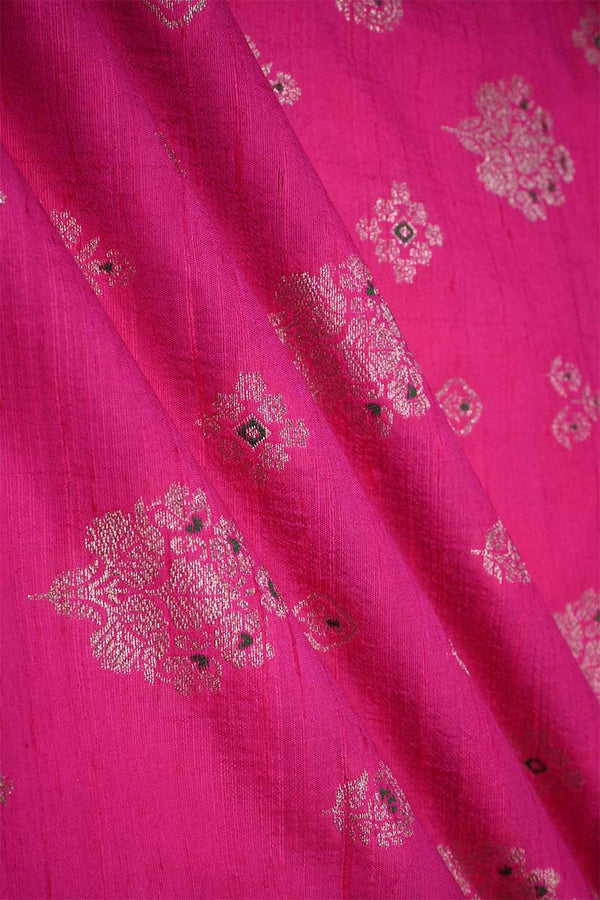 Close-up of pink raw silk fabric with gold and green floral patterns