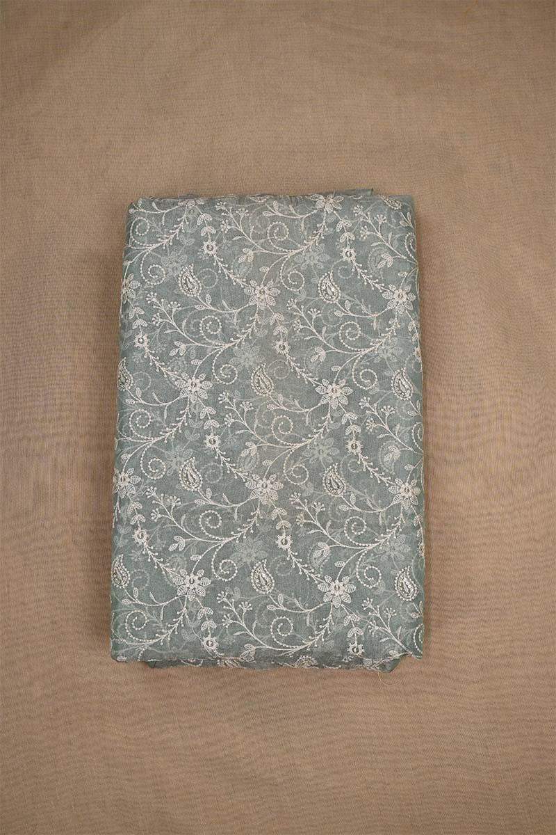 An embroidered grey fabric with floral patterns on beige background