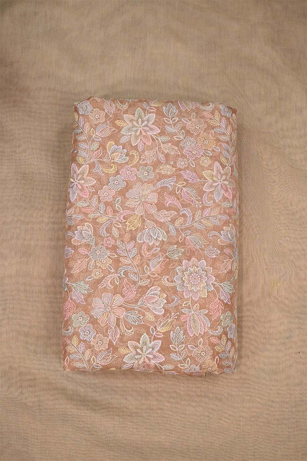 Close-up of multicolor floral pattern embroidered peach fabric  on beige background