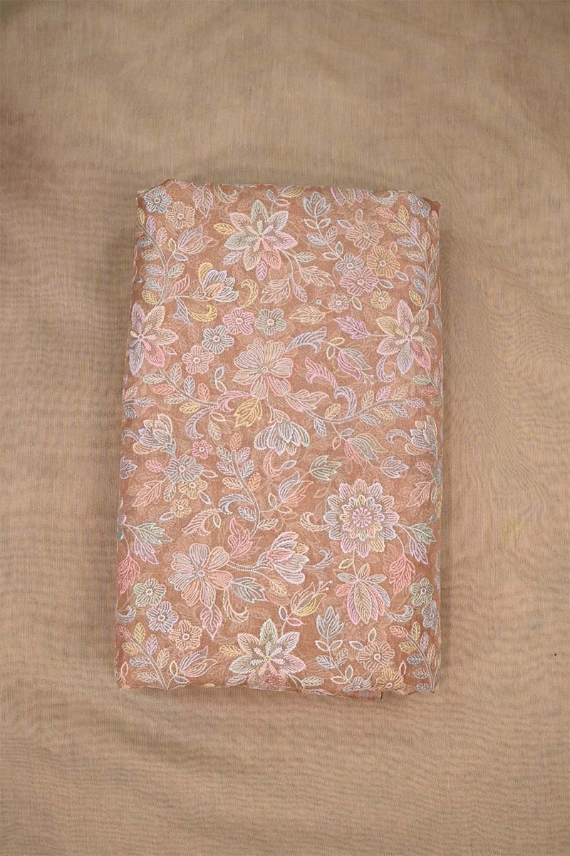 Close-up of multicolor floral pattern embroidered peach fabric  on beige background