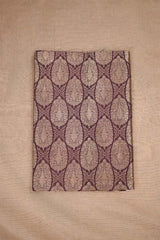 Close-up of a brown banarasi silk fabric with intricate floral brocade pattern on beige background