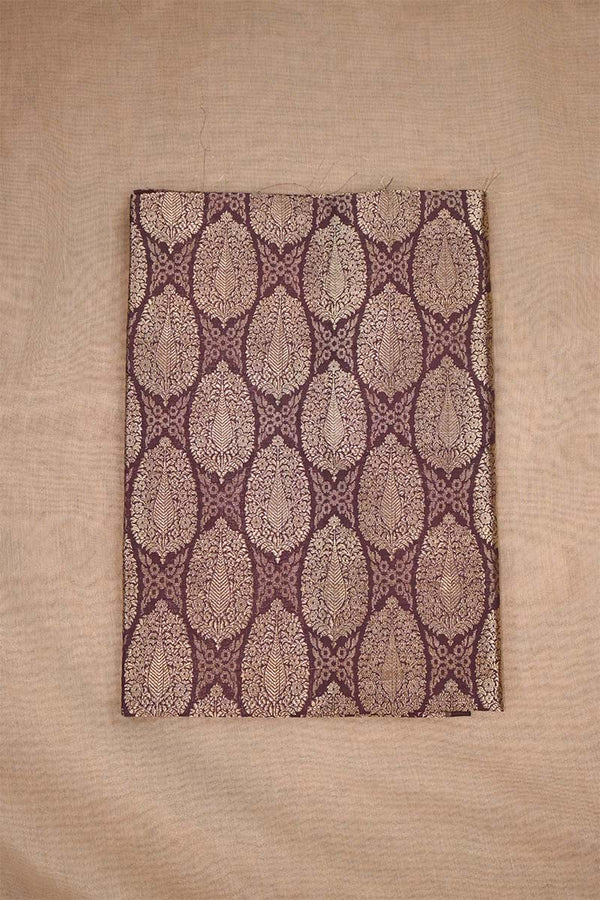 Close-up of a brown banarasi silk fabric with intricate floral brocade pattern on beige background