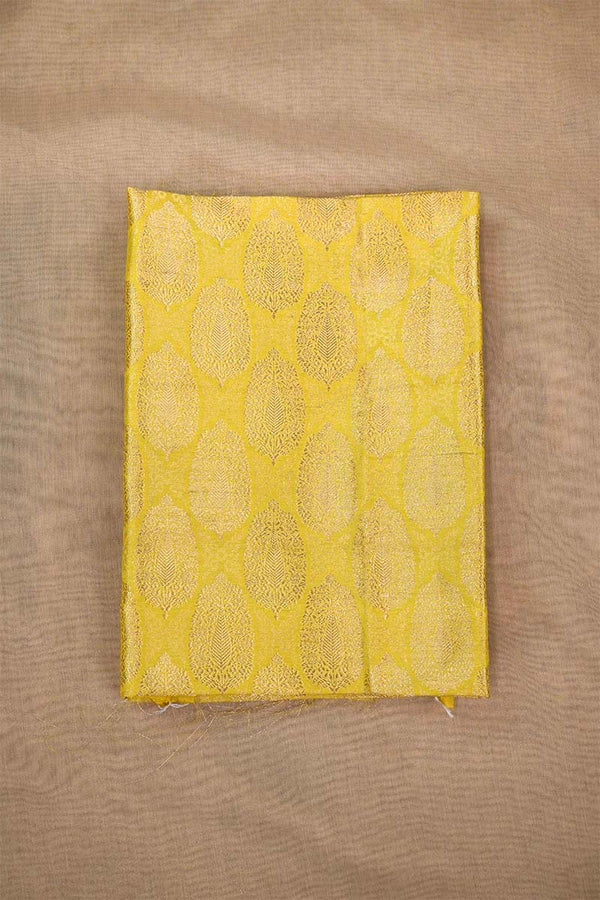 Close-up of a yellow banarasi silk fabric with intricate floral brocade pattern on beige background