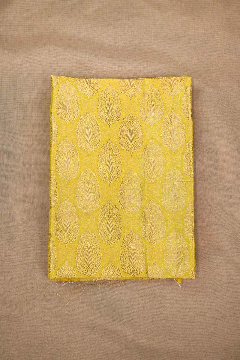 Close-up of a yellow banarasi silk fabric with intricate floral brocade pattern on beige background