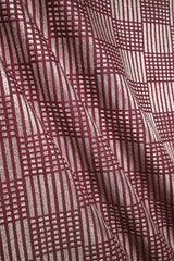 Close-up of a maroon Banarasi silk fabric with a subtle geometric pattern