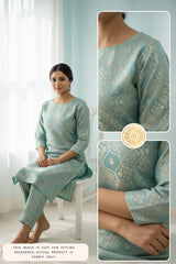 Woman wearing a light blue Banarasi kurti and pant with intricate patterns, sitting on a white chair.