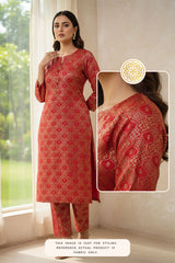 Red patterned kurta with matching pants in a room with a window.