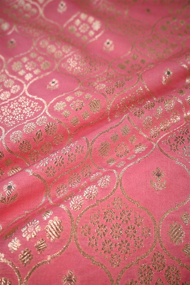 Close-up of pink fabric with gold intricate patterns