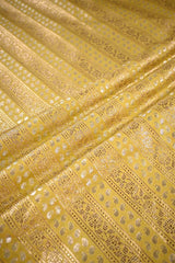 Close-up of yellow fabric with intricate gold patterns