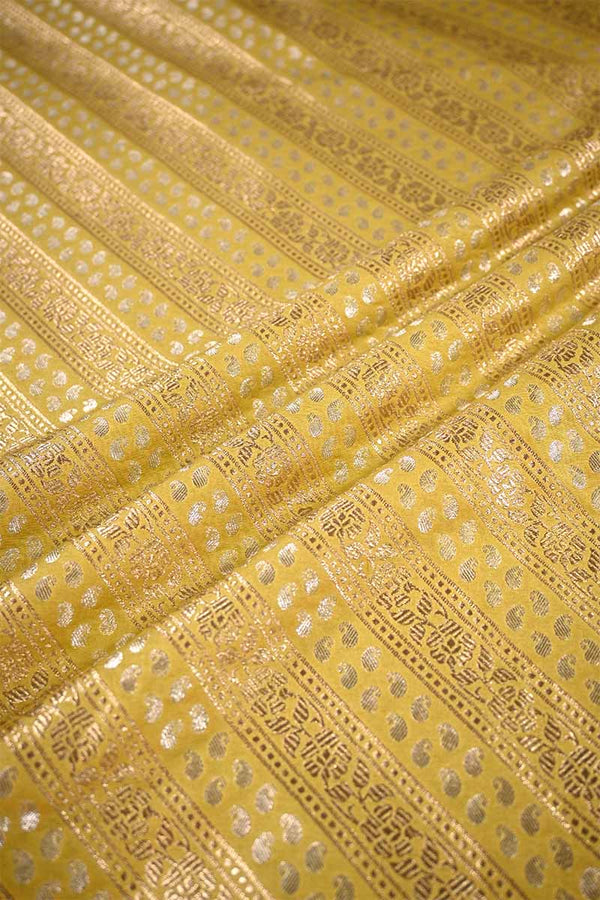 Close-up of yellow fabric with intricate gold patterns