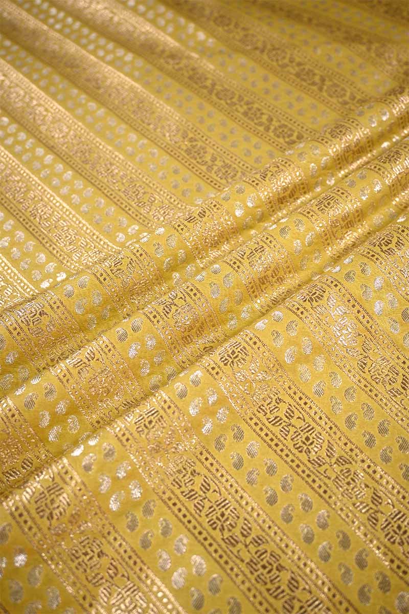 Close-up of yellow fabric with intricate gold patterns