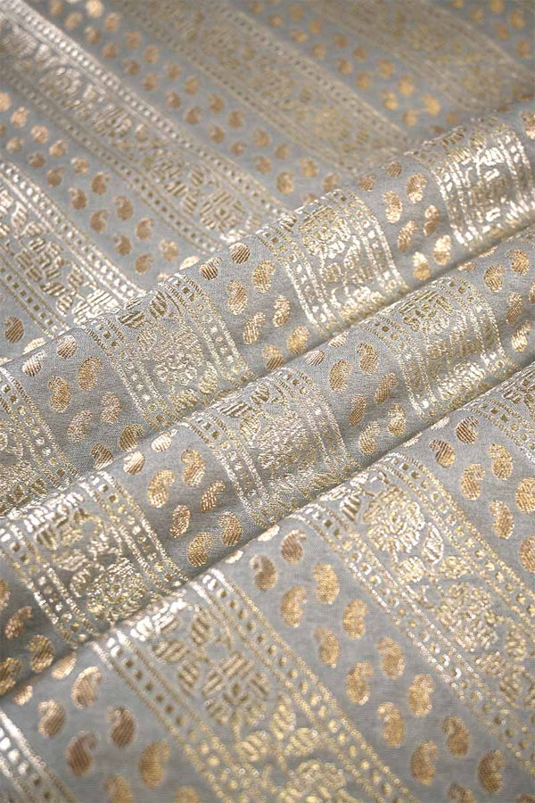 Close-up of metallic gold fabric pattern on gray background