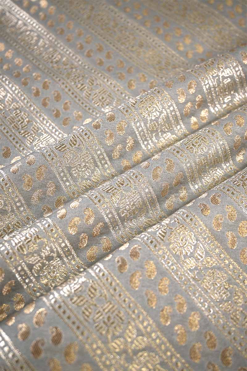 Close-up of metallic gold fabric pattern on gray background