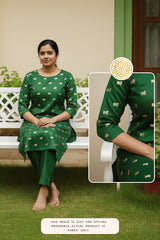 Woman wearing a green kurti pant with pichwai cow motif pattern, sitting on white bench in garden